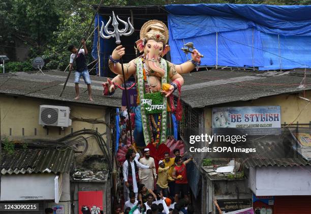 An Idol of elephant-headed Hindu god Ganesh passes through a narrow lane during the immersion procession. Anant Chaturdashi marks the end of a ten...