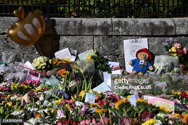 Floral tributes are seen together with a Paddington bear toy outside Balmoral Castle in Ballater, on September 10 two days after Queen Elizabeth II...