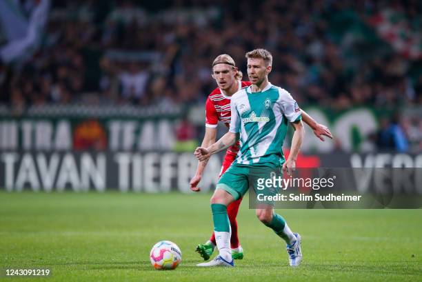 Fredrik Jensen of Augsburg fights for the ball with Mitchell Weiser of Bremen during the Bundesliga match between SV Werder Bremen and FC Augsburg at...