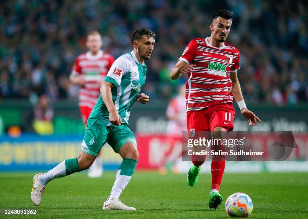 Milos Veljkovic of Bremen fights Mergim Berisha of Augsburg for the ball with during the Bundesliga match between SV Werder Bremen and FC Augsburg at...