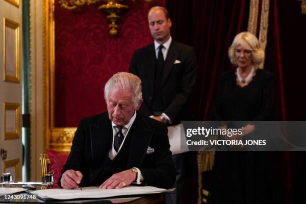 Britain's Prince William, Prince of Wales and Britain's Camilla, Queen Consort watch as Britain's King Charles III signs an oath to uphold the...
