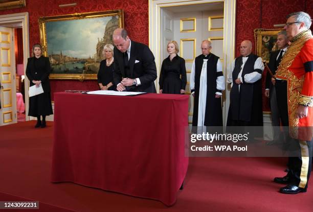 The Prince of Wales signs the Proclamation of Accession of King Charles III, watched by Lord President of the Council Penny Mordaunt, the Queen,...