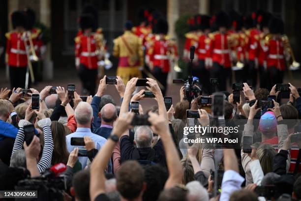 Members of the public listen as David Vines White, Garter King of Arms reads the Principal Proclamation, from the balcony overlooking Friary Court...