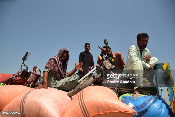 Victims of flooding from monsoon rains carry their belongings from their flooded home in Sehwan, Pakistan on September 09, 2022.
