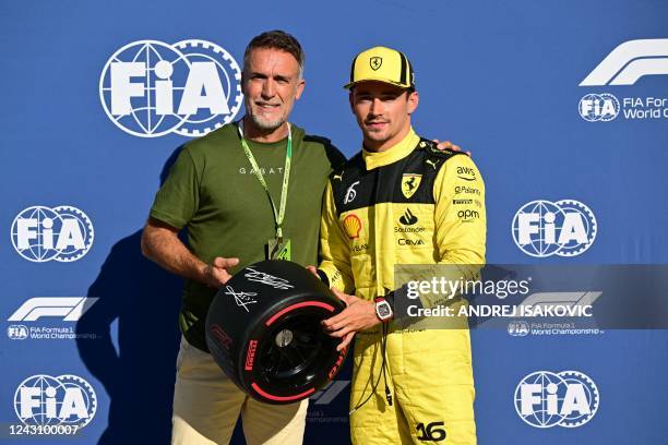 Ferrari's Monegasque driver Charles Leclerc poses with former footballer Gabriel Batistuta after placing first in the qualifying session ahead of the...