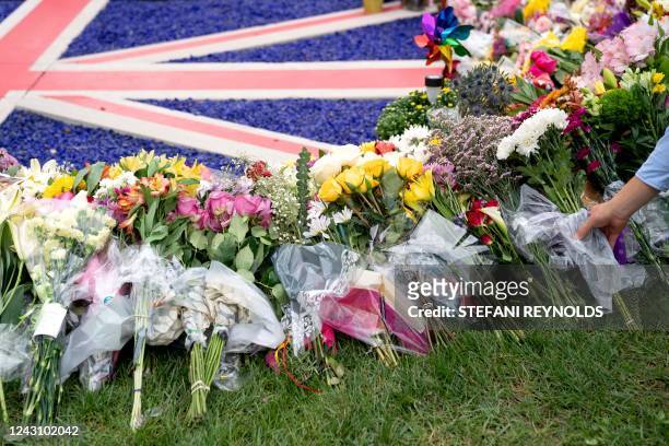 People leave flowers for Britain's Queen Elizabeth II at a makeshift memorial outside the British Embassy in Washington, DC, on September 9, 2022....