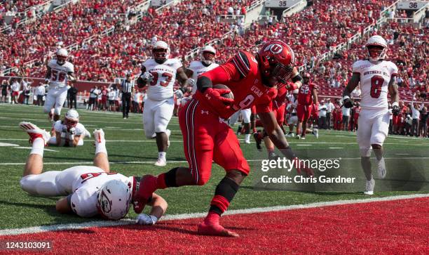 Tavion Thomas of the Utah Utes scores a touchdown against Kohler Cullimore of the Southern Utah Thunderbirds during the first half of their game...