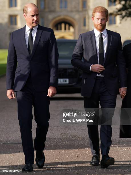 Prince William, Prince of Wales and Prince Harry, Duke of Sussex walk together to meet members of the public on the long Walk at Windsor Castle on...
