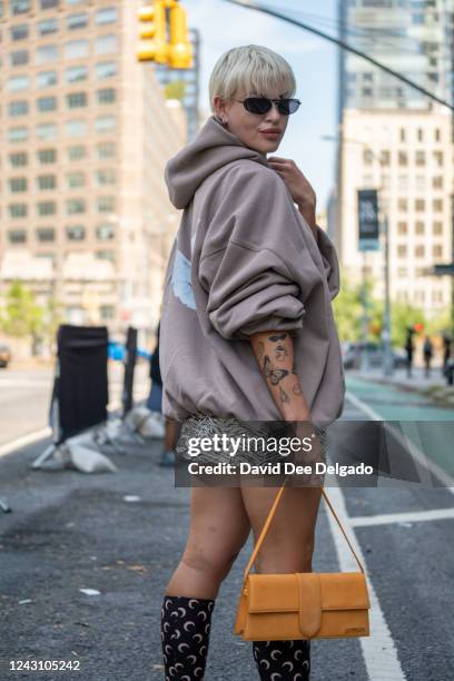 Veronica Guilty is seen wearing a Yeezy Gap Baleciaga hoodie, dress by Reformation, shoes Marine Serre and a bag by Jacquemus to NYFW at Spring...