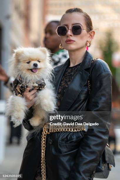 Urszula Makowska, with Mochi the pomeranian, is seen wearing a catsuit by Fleur De Mal, jacket by Karen Millen, bag by Chanel to NYFW at Spring...