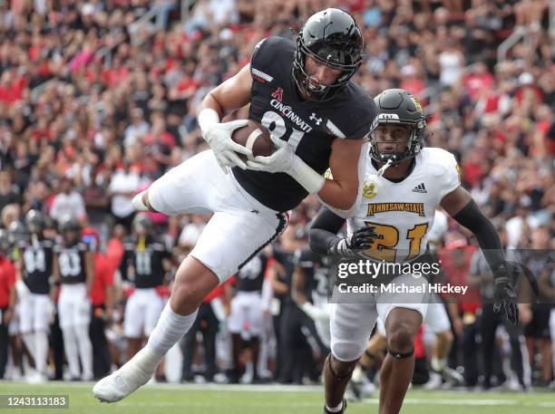 Josh Whyle of the Cincinnati Bearcats makes a touchdown catch as Markeith Montgomery of the Kennesaw State Owls looks on during the first half at...