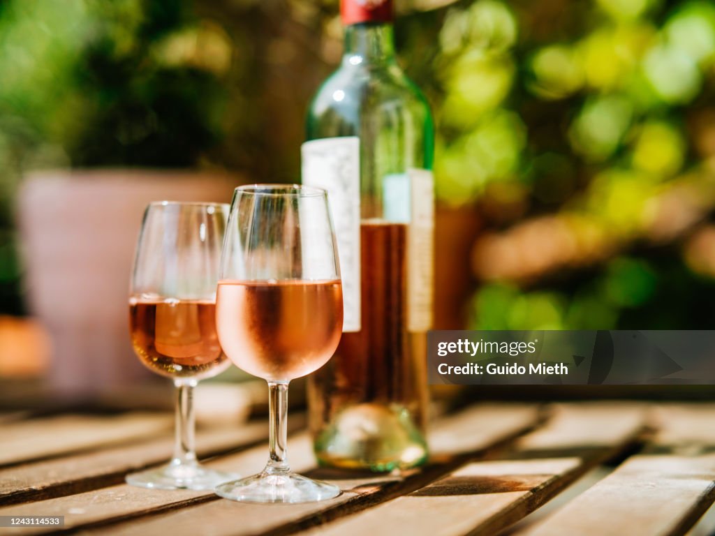 Glass of wine on a table in sunlight.