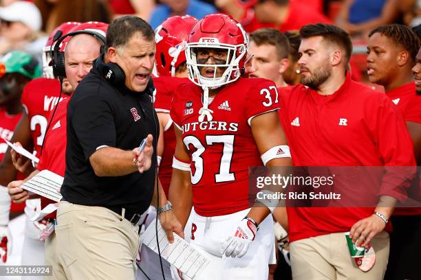 Head coach Greg Schiano of the Rutgers Scarlet Knights talks with Joe Lusardi of the Rutgers Scarlet Knights during the second quarter of a college...