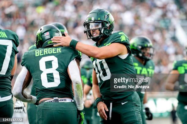 Payton Thorne of the Michigan State Spartans celebrates a touchdown with Jalen Berger of the Michigan State Spartans against the Akron Zips during...