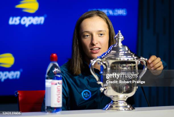 Iga Swiatek of Poland finds a tiramisu surprise in her champions trophy while talking to the media after defeating Ons Jabeur of Tunisia in the final...