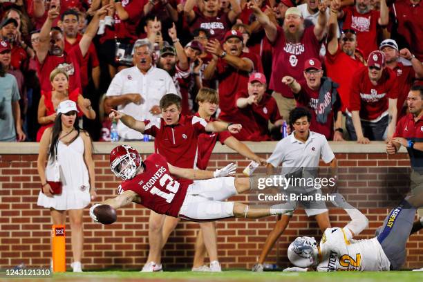 Wide receiver Drake Stoops of the Oklahoma Sooners dives for a touchdown after slipping free of the grasp of linebacker Shane Slattery of the Kent...