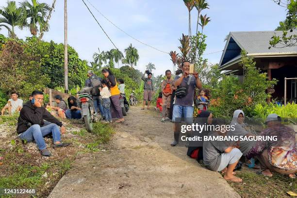 People gather outside their homes following an earthquake off Indonesia's Mentawai Islands, at Muara Sikabaluan village in Siberut Utara, West...