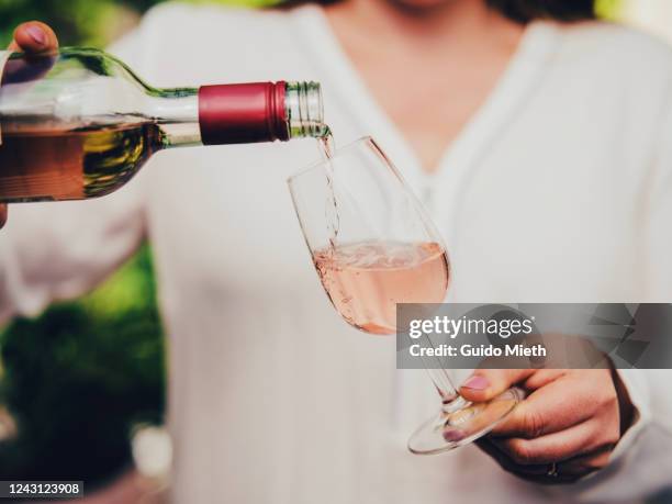 woman pouring wine in glass. - rose wine stock pictures, royalty-free photos & images
