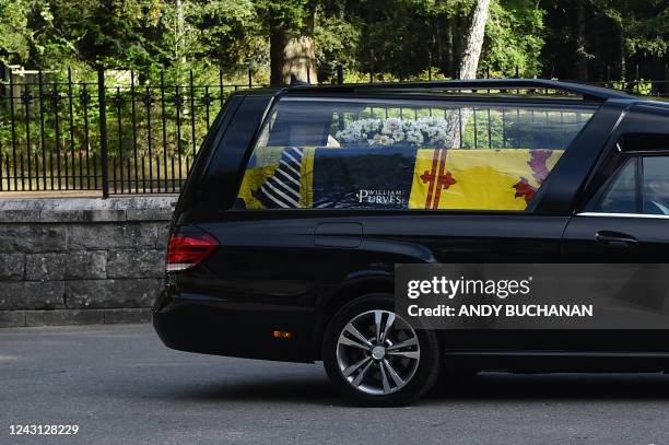 The hearse carrying the coffin of Queen Elizabeth II covered with the Royal Standard of Scotland and a flowers is driven away from Balmoral Castle in...
