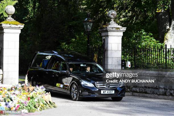 The hearse carrying the coffin of Queen Elizabeth II covered with the Royal Standard of Scotland and a flowers is driven away from Balmoral Castle in...