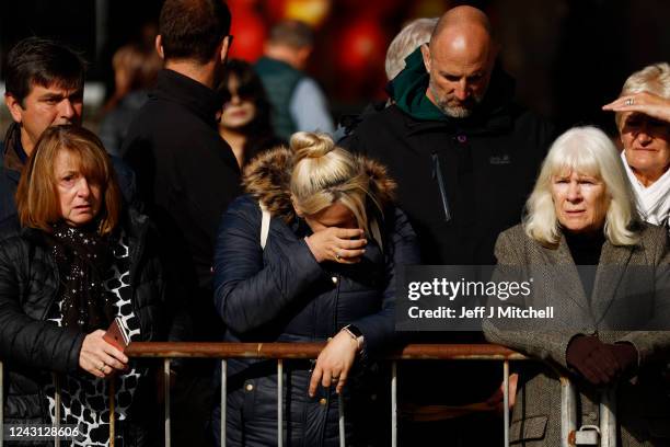 People gather in tribute as the cortege carrying the coffin of the late Queen Elizabeth II passes by on September 11, 2022 in Ballater, United...