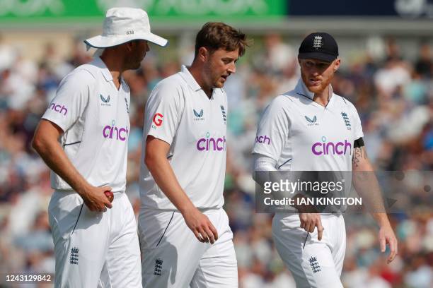 England's Stuart Broad, Ollie Robinson and captain Ben Stokes speak during play on the fourth day of the third Test cricket match between England and...