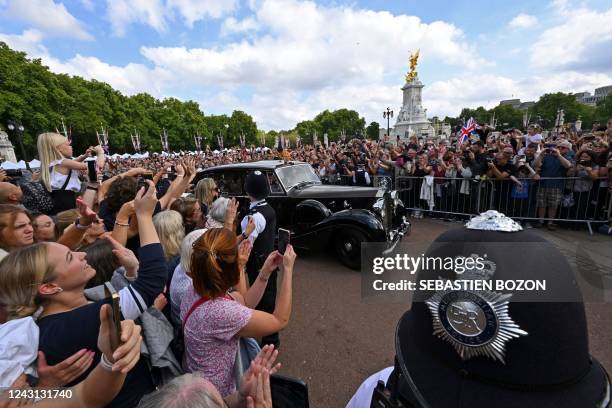 The cypher of the late Queen Elizabeth II is seen on the helmet of a police officer, as members of the public gather to watch Britain's King Charles...