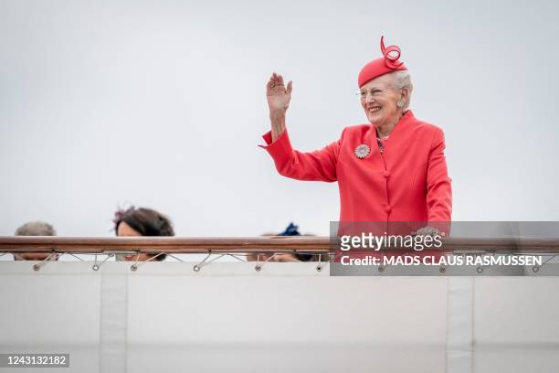 Queen Margrethe II of Denmark waves upon departure of the Dannebrog Royal Yacht, in Copenhagen, on September 11 during the 50th anniversary of her...