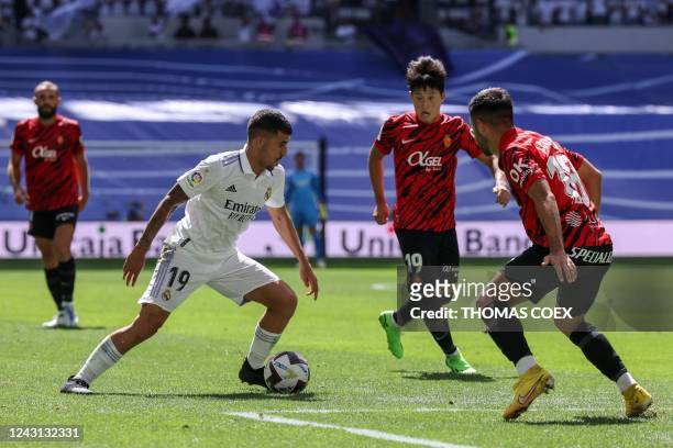 Real Madrid's Spanish midfielder Dani Ceballos fights for the ball with Real Mallorca's South Korean forward Lee Kang-in and Real Mallorca's Spanish...