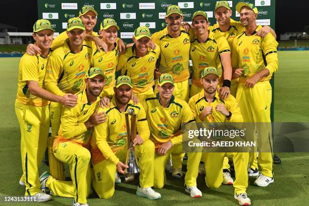 Australia's captain Aaron Finch holds the Chappell-Hadlee Trophy celebrates with teammates after winning the third one-day international cricket...