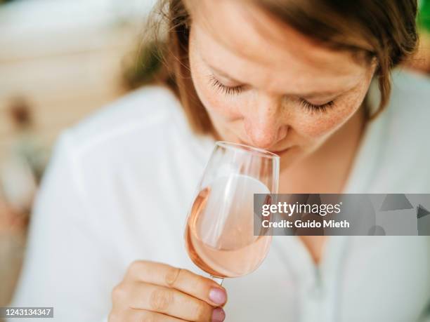 happy woman enjoying rose wine tasting in sunlight. - single rose stockfoto's en -beelden