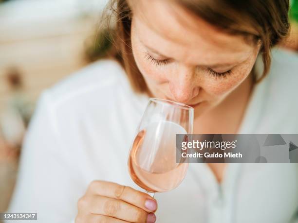 happy woman enjoying rose wine tasting in sunlight. - wine enjoyment stock pictures, royalty-free photos & images