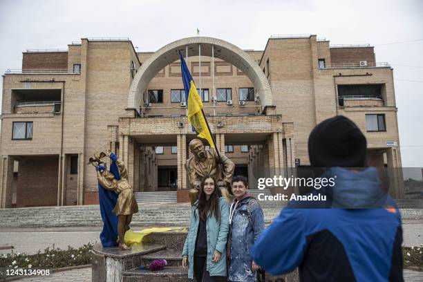 People pose in front of Taras Shevchenko statue with an Ukrainian after Ukrainian army liberated the town of Balakliya in the southeastern Kharkiv...