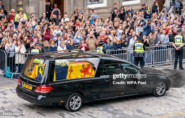 The hearse carrying the coffin of Queen Elizabeth II, draped with the Royal Standard of Scotland, passes the City Chambers on the Royal Mile,...