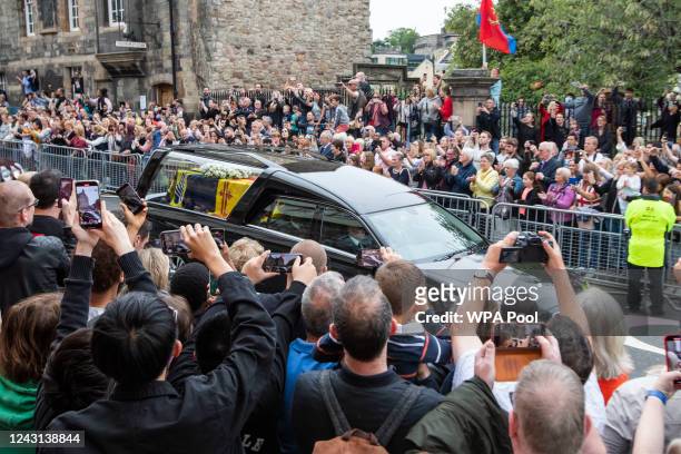 People gather on the Royal Mile at Cannongate Kirk to watch the cortege carrying the coffin of the late Queen Elizabeth II, draped with the Royal...