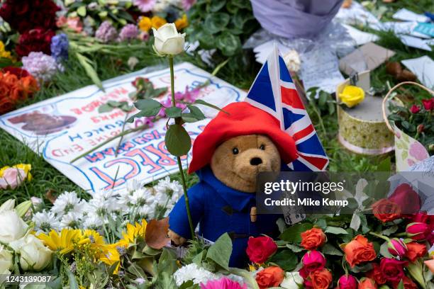 Close up of floral tributes and a toy Paddington Bear as public gather to lay flowers at a temporary memorial garden in Green Park following the...