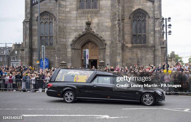 Crowds gather on Lothian Road to pay their respects as the hearse carrying the coffin of Queen Elizabeth II, draped with the Royal Standard of...