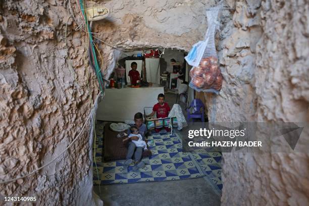 Children of Palestinian Jaber Dababse sit together inside a cave in the Khashem al-Daraj village of Masafer Yatta area, where evictions of...