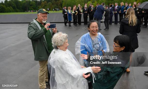 Yachiyo Huge, mother of victim Toshiya Huge greets National Park Service volunteer Ginny Barnett at the Wall of Names during a ceremony commemorating...