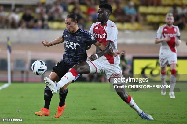 Lyon's French midfielder Maxence Caqueret fights for the ball with Monaco's French defender Benoit Badiashile during the French L1 football match...