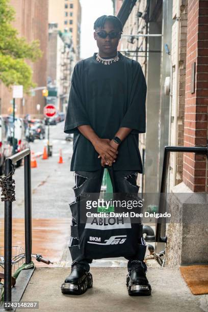 Joseph Holland is seen wearing a necklace by Balenciaga x Gucci, shirt Yeezy Gap Balenciaga, shoes by Balenciaga Crocs, bag by Figures of Speech x...