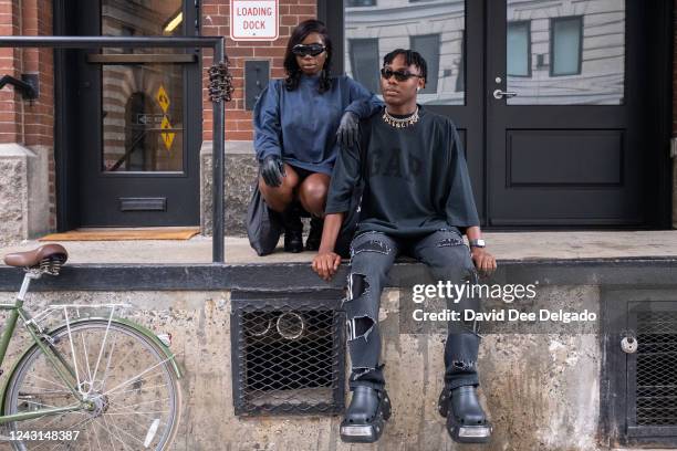 Drusilla Arhin is seen wearing a shirt Yeezy Gap Balenciaga, boots by Ego, gloves and glasses by Amazon Fashion and Joseph Holland is seen wearing a...