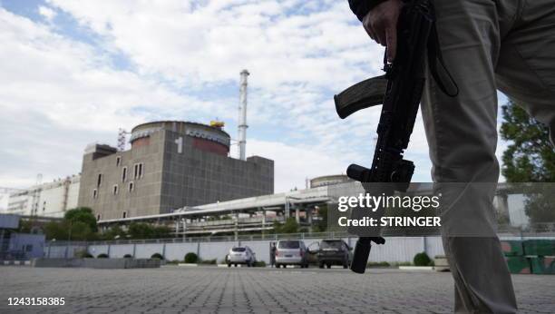 This photo taken on September 11, 2022 shows a security person standing in front of the Zaporizhzhia Nuclear Power Plant in Enerhodar , Zaporizhzhia...