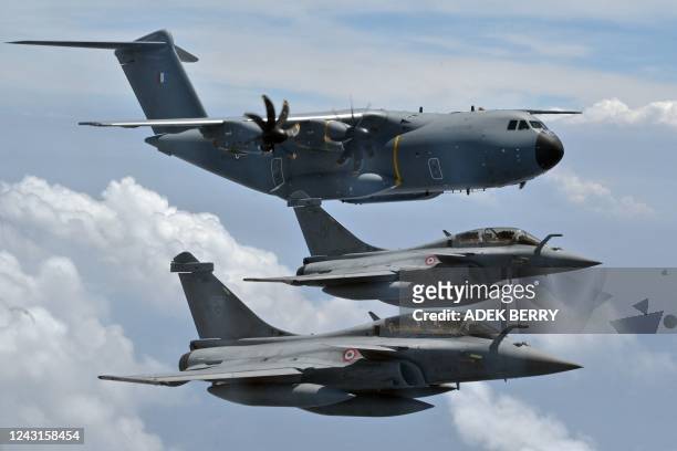 Dassault Rafale multirole combat aircraft and an Airbus A400M airlifter fly in formation during a demonstration flight by the French Air Force over...