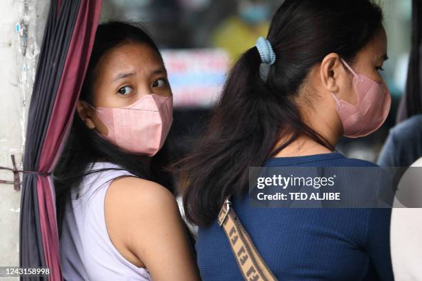 Face-mask clad commuters ride on a tricycle in Manila on September 12, 2022. - The Philippines on September 12 lifted a requirement for masks to be...