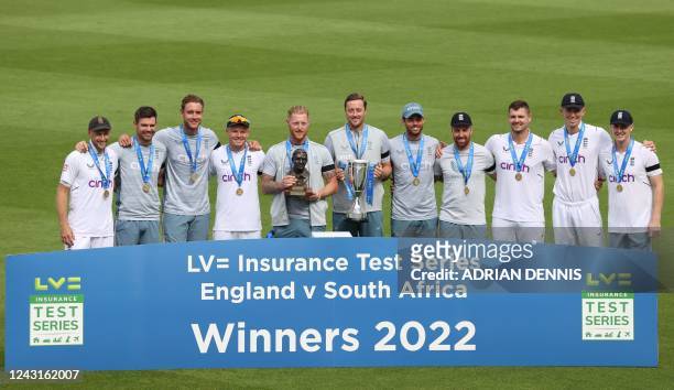 England's captain Ben Stokes holds the trophy as he poses with his players : Joe Root, James Anderson, Stuart Broad, Ollie Pope, Ollie Robinson, Ben...