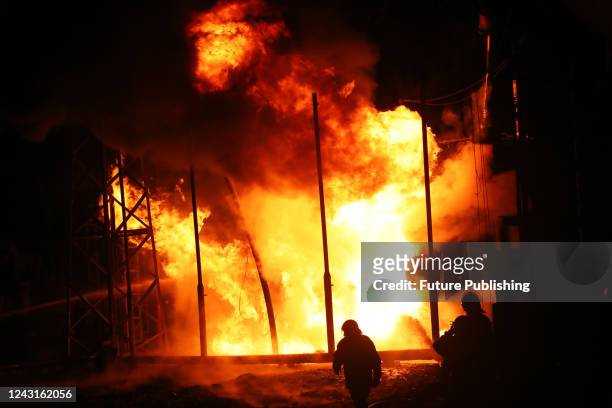 Firefighters of the State Emergency Service work to put out the fire which erupted after a Russian missile attack at the energy facility, Kharkiv...