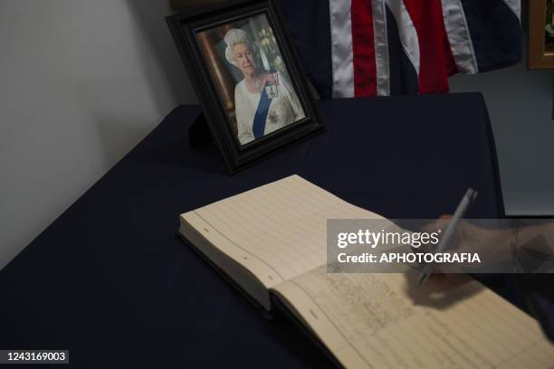 Woman signs a condolences book set for Salvadorans to sign at the British Embassy in El Salvador on September 12, 2022 in San Salvador, El Salvador....