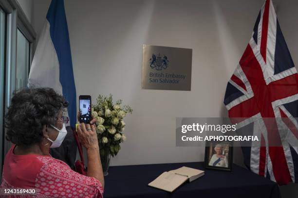 Woman takes pictures of a memorial set for Queen Elizabeth II at the British Embassy in El Salvador on September 12, 2022 in San Salvador, El...