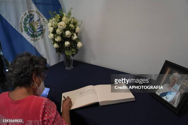 Woman signs a condolences book set for Salvadorans to sign at the British Embassy in El Salvador on September 12, 2022 in San Salvador, El Salvador....